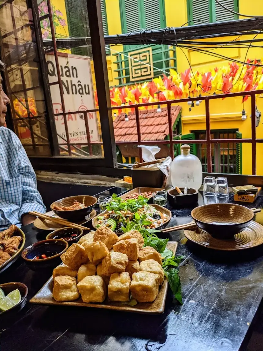 Nhìn từ bàn ra ngõ: nhà tường vàng, chong chóng giấy đỏ cam